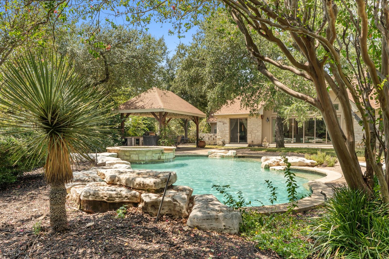 Pool with boulder edging and cabana beyond