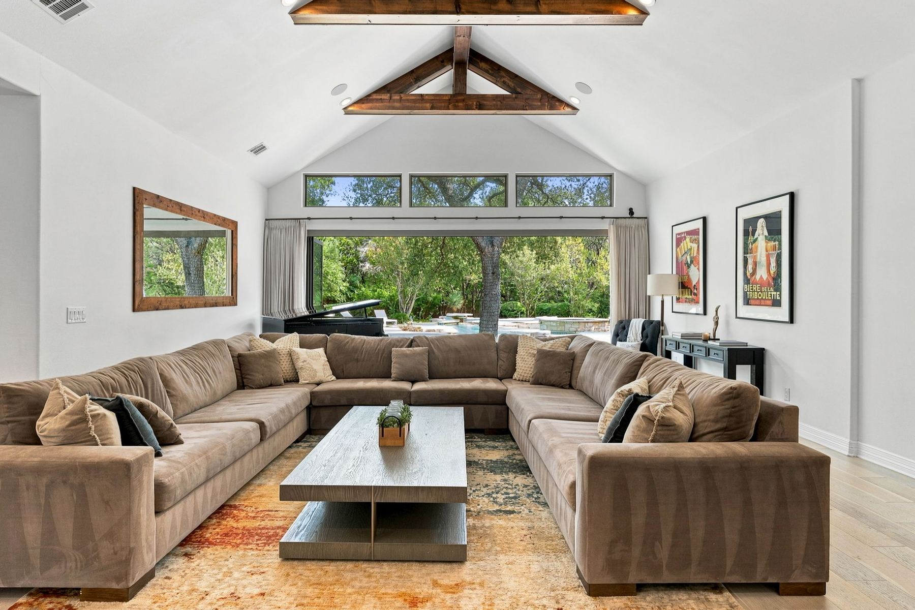 Great room with exposed wood trusses and sectional seating