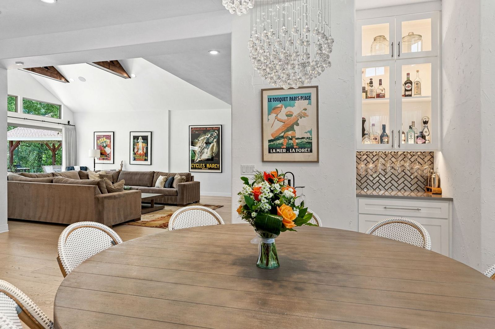 Dining table beside a lit glass bar