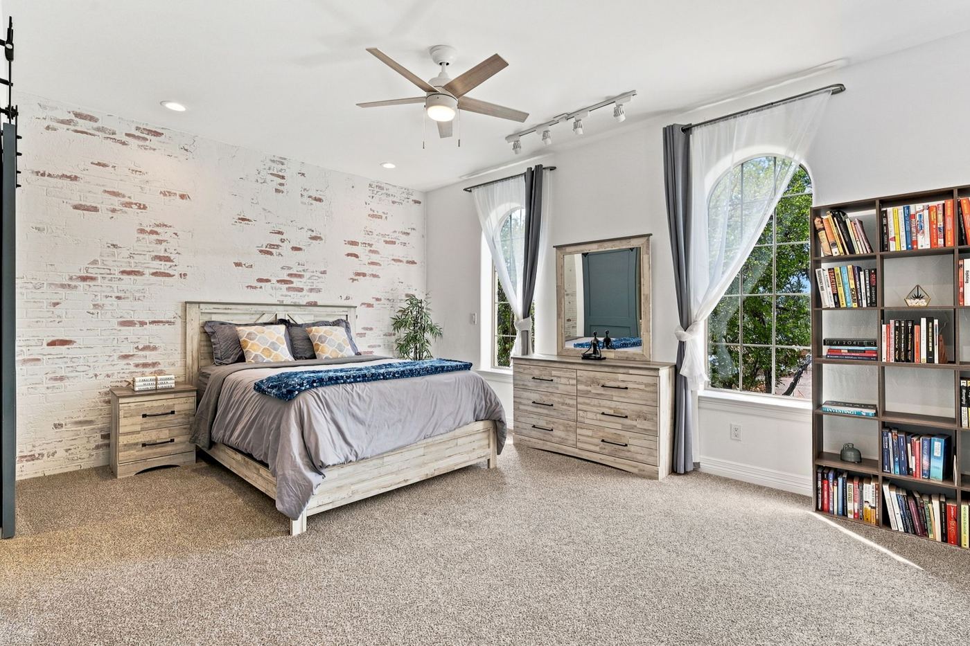 Bedroom with whitewashed brick wall and arched windows