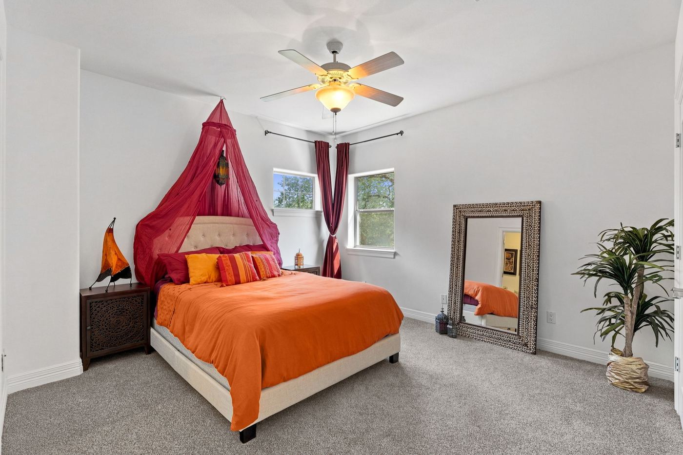 Bedroom with saffron bedding and a red canopy